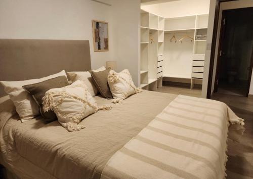 1 cama grande con almohadas en el dormitorio en Amapola's II en Salta