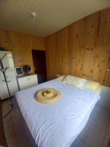 ein Bett mit einem Strohhut darüber in der Unterkunft Casa de Veraneio em São Francisco do Sul - Praia do Ervino in São Francisco do Sul