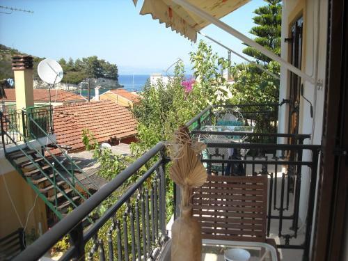 a balcony with a chair and a view of the ocean at Soustas Apartments in Longos