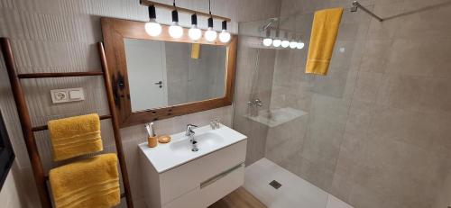 a bathroom with a sink and a mirror and a shower at Casilla de Costa Luz Home con Terrazza Fronte Piscina in La Oliva