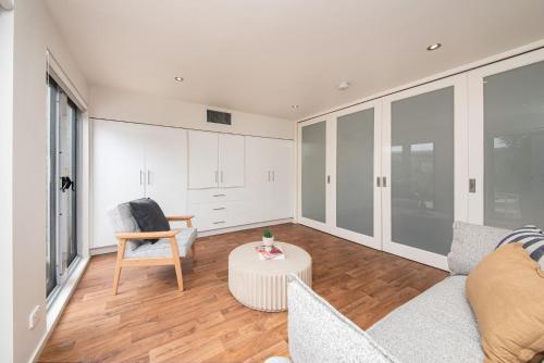 a living room with a couch and a table at Groves Sunset Views in Aspendale in Aspendale