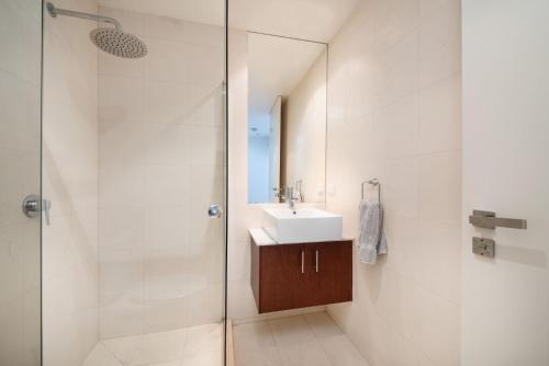 a bathroom with a sink and a shower at Groves Sunset Views in Aspendale in Aspendale