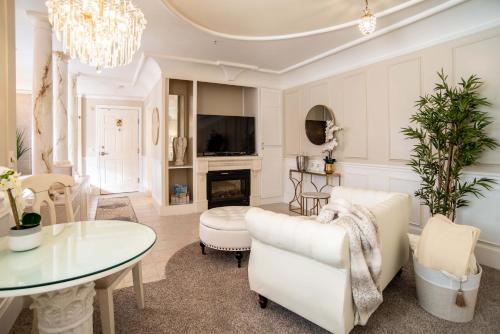 a living room with white furniture and a chandelier at The Anniversary Inn - Boise in Boise
