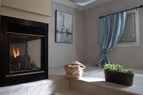 a bathroom with a fireplace and a blue curtain at The Anniversary Inn - Boise in Boise