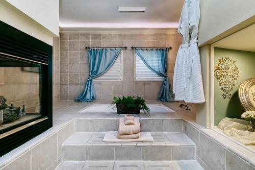 a bathroom with a soaking tub with blue curtains at The Anniversary Inn - Boise in Boise