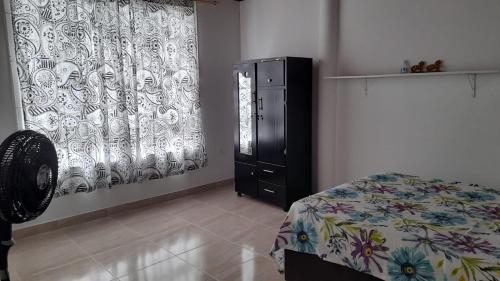 1 dormitorio con 1 cama, vestidor y cortina en Apartahotel Zamflor, en Puerto Asís