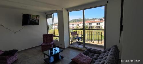 a living room with a couch and a large window at * APARTAMENTO CON HERMOSA VISTA in Manizales