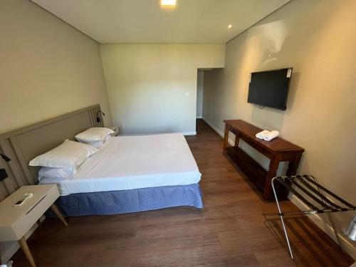 mały pokój z łóżkiem i telewizorem w obiekcie Pousada Jardim Da Lagoa w mieście Florianópolis