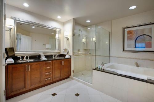 a bathroom with a tub and a sink and a shower at Entire Strip View Suite in Las Vegas