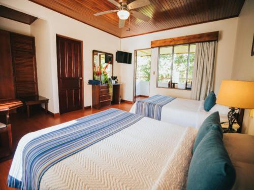 a large bedroom with two beds and a television at Tilajari Hotel Resort in Fortuna