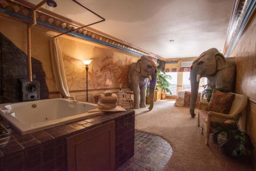 two elephants standing in a bathroom with a tub at The Anniversary Inn - Boise in Boise