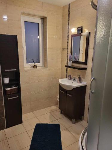 a bathroom with a sink and a mirror at Domki Nad Jeziorem 781-281-434 in Polańczyk