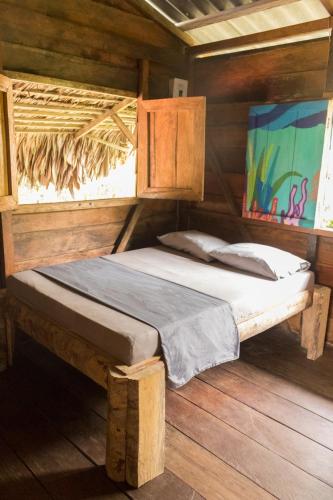 ブエナベントゥラにあるCoco House - Playa La Barraの木造キャビン内のベッド1台が備わるベッドルーム1室を利用します。