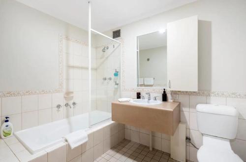 ein Badezimmer mit einem Waschbecken, einer Badewanne und einem WC in der Unterkunft 708 Enchanting Urbanoasis 1brbalconycbd in Perth