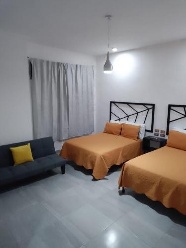 a room with two beds and a couch in it at MCI HOTEL in San Juan de los Lagos