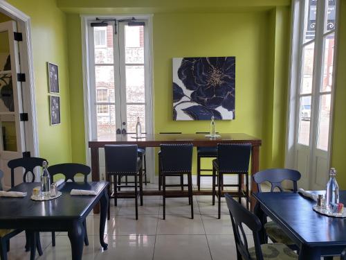 a dining room with green walls and tables and chairs at Natchez Manor Bed & Breakfast in Natchez