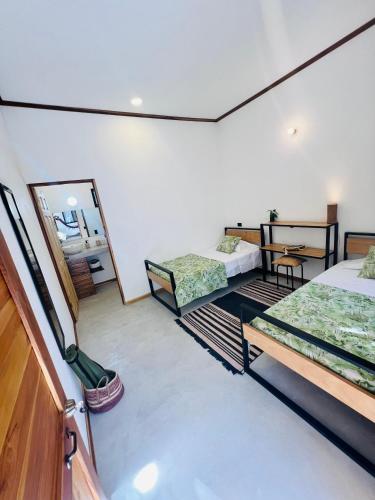 a room with two beds and a mirror at Calipso Ocean Lodge- Avellana Beach Hotel in Playa Avellana
