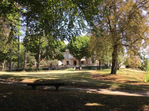 un parco con panchina di fronte a una casa di Hotel-Musée Villa Bagatelle a Irigny