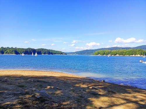 a view of a large body of water with sailboats at Domki Nad Jeziorem in Polańczyk