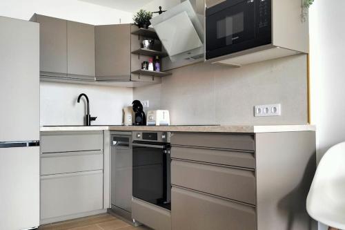 a kitchen with white cabinets and a black oven at Luxury Penthouse Valentin with jacuzzi in Corralejo