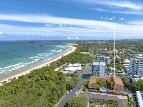 an aerial view of a beach and buildings at Hawaiian Gardens 17 in Coffs Harbour