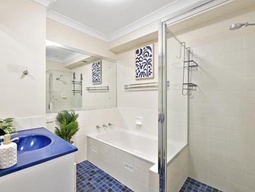 uma casa de banho com uma banheira e um lavatório em Hawaiian Gardens 17 em Coffs Harbour