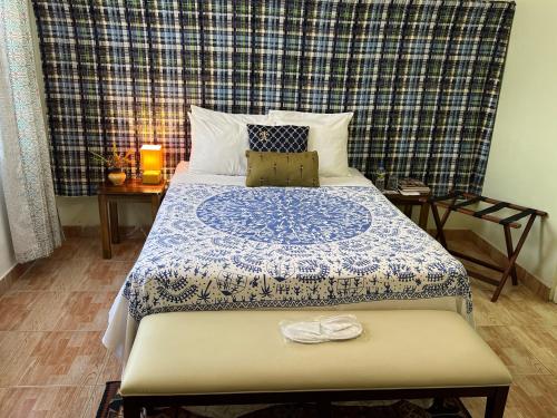 um quarto com uma cama com um cobertor azul e branco em RNM The Clubhouse, Grenada em Mount Nesbit