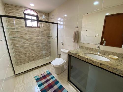 uma casa de banho com um chuveiro, um WC e um lavatório. em Recanto da Paz, Miguel Pereira RJ em Miguel Pereira