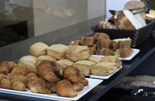 un mucchio di diversi tipi di pasticcini su piatti di SAMARÁN SUITES a Villa María
