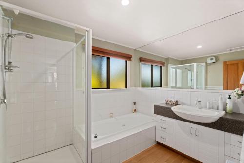 a bathroom with a tub and a sink and a shower at Mountain View Lodge in Queenstown