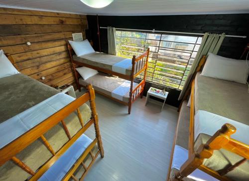 a room with two bunk beds and a window at Casa do Rogério Hostel in Caxias do Sul