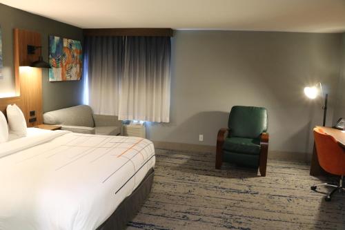 a hotel room with a bed and a chair at La Quinta by Wyndham Chicago Gurnee in Gurnee