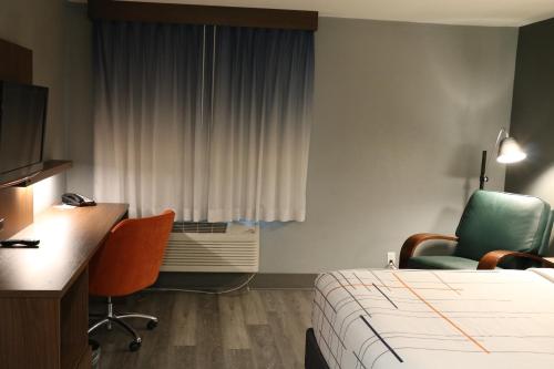 a hotel room with a bed and a desk and chair at La Quinta by Wyndham Chicago Gurnee in Gurnee