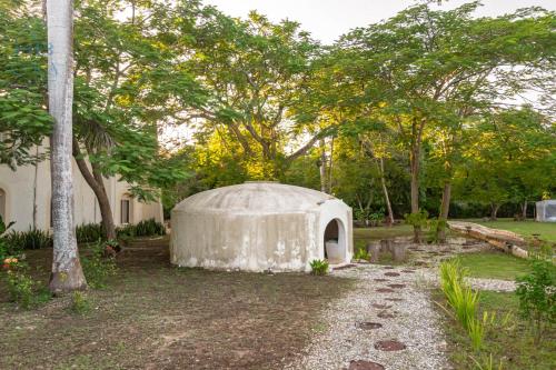a large white building in a yard with trees at Kaab Coba in Cobá