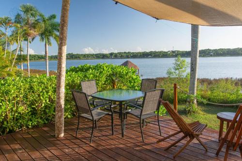 a table and chairs on a deck with a view of the water at Kaab Coba in Cobá