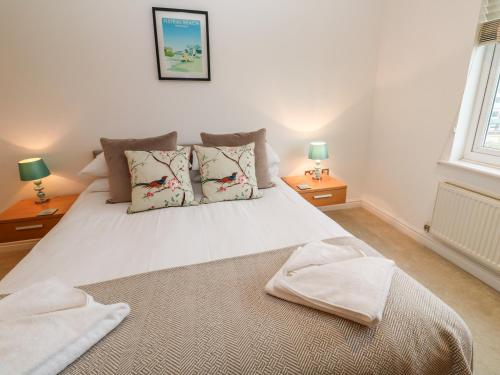 a bedroom with a large white bed with two lamps at 9 Headland Point in Newquay