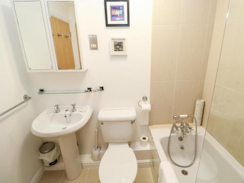 a bathroom with a toilet and a sink and a tub at 9 Headland Point in Newquay