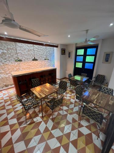 a dining room with tables and chairs and windows at The Orange House Santa Marta in Santa Marta