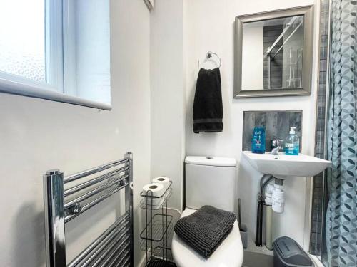 a white bathroom with a sink and a toilet at Cheam Village Self Contained Flat & studio in Cheam