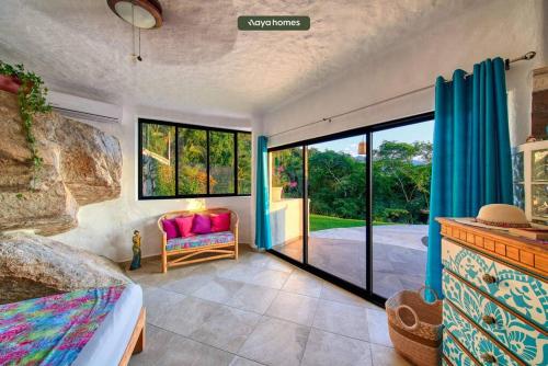 Casa de las Ventanas في بويرتو فايارتا: غرفة بسرير وأريكة ونوافذ
