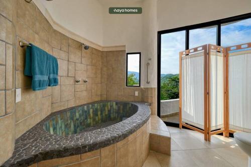 Casa de las Ventanas في بويرتو فايارتا: حمام مع حوض كبير مع نافذة