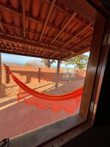una hamaca naranja sentada en el lateral de un edificio en The Rose's Cottage (Chalé da Rose) en Icapuí