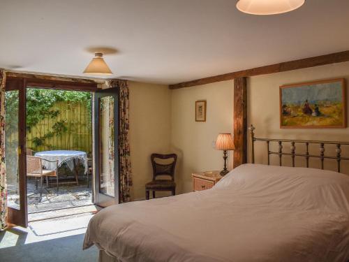 a bedroom with a bed and a sliding glass door at Chetnole Mill in Chetnole