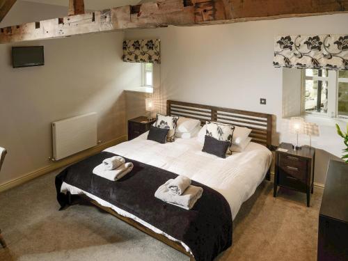 a bedroom with a large bed with towels on it at Howgills Barn in Middleton