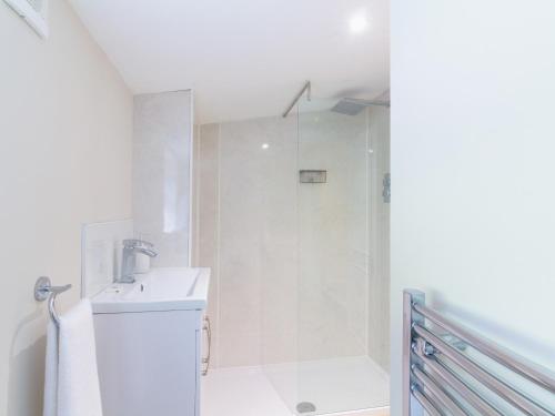 a white bathroom with a shower and a sink at Dalnaglar Cottage - Uk30260 in Cray