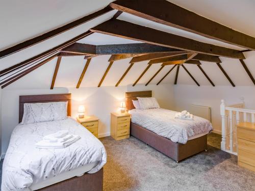 two twin beds in a room with exposed beams at Wester Caiplich - Uk30261 in Cray