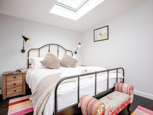 a bedroom with a bed with white sheets and pillows at Stargazing Retreat - Uk32423 in Merton