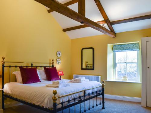 a bedroom with a large bed and a window at 1 The Reading Room Cottages - Uk37359 in Barningham