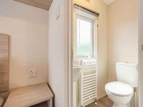 a bathroom with a toilet and a window at Burray in Mey