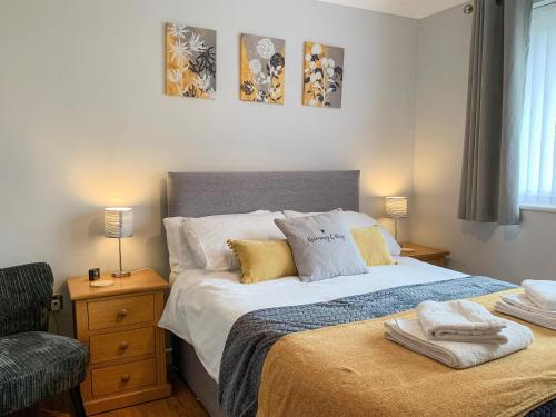 a bedroom with a large bed and a chair at Rosemary Cottage-uk42032 in Highampton